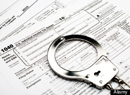 handcuffs on an American 1040 income tax form indicating tax fraud or evasion